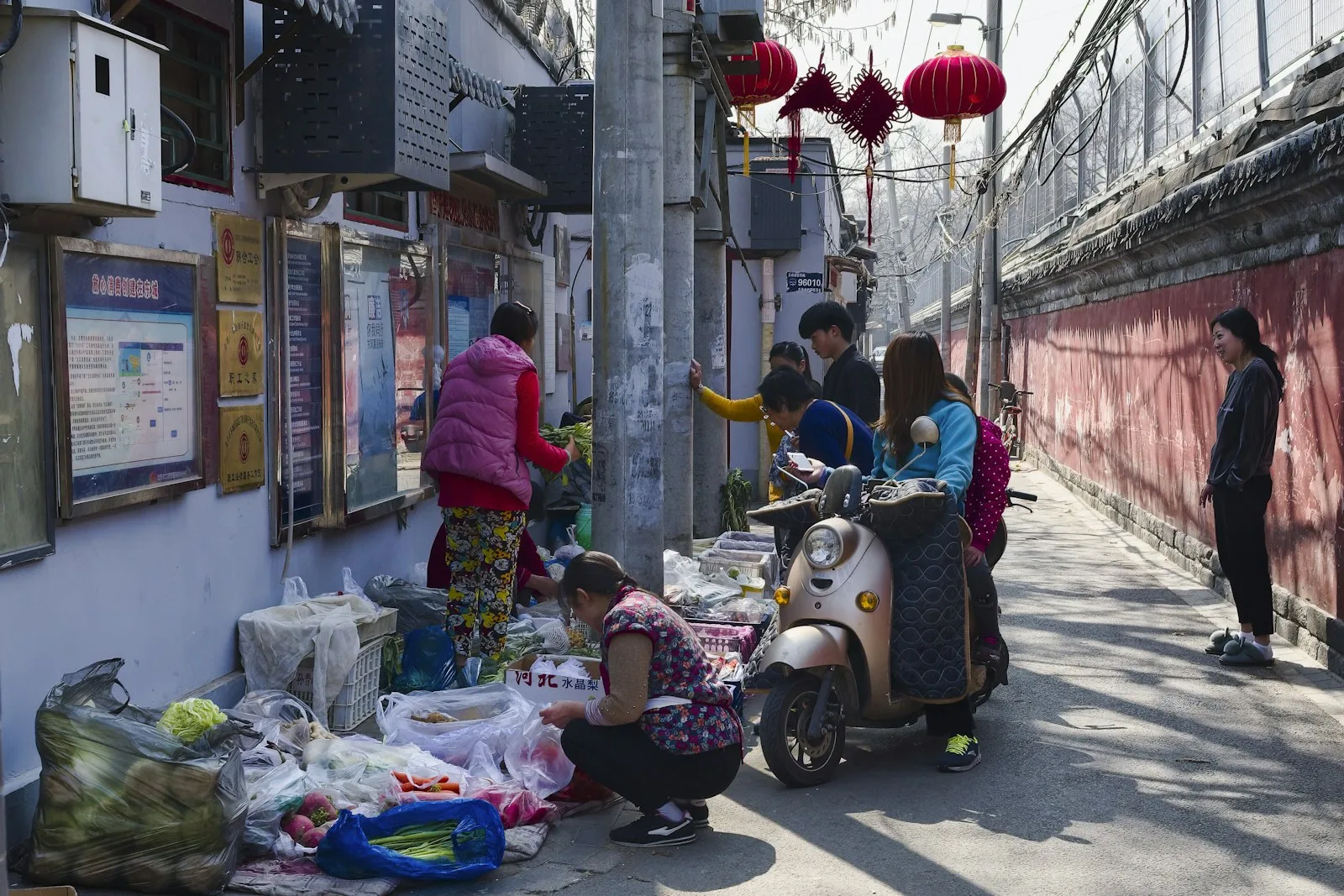 Neighbors shopping at a small street market in a Beijing hutong